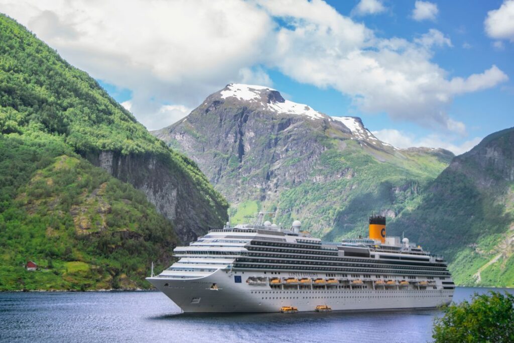 Gran barco de crucero navegando por el Geirangerfjord en Noruega rodeado de montañas majestuosas