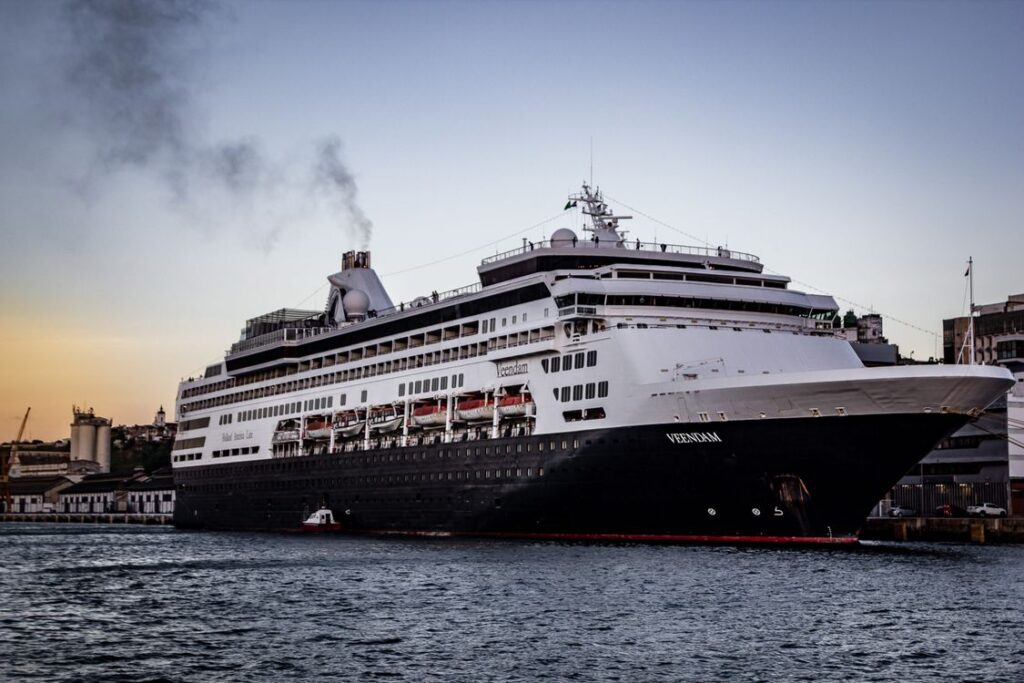 Gran barco de crucero de lujo amarrado en un puerto iluminado al atardecer durante las fiestas de Navidad