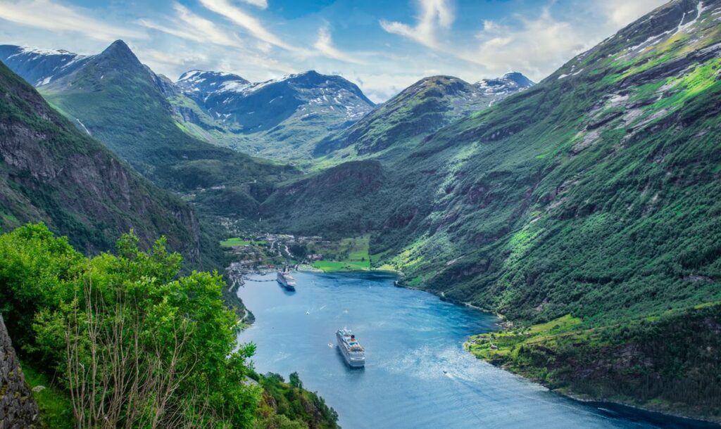 Vista aerea del Geirangerfjord con barco crucero entre montanas verdes